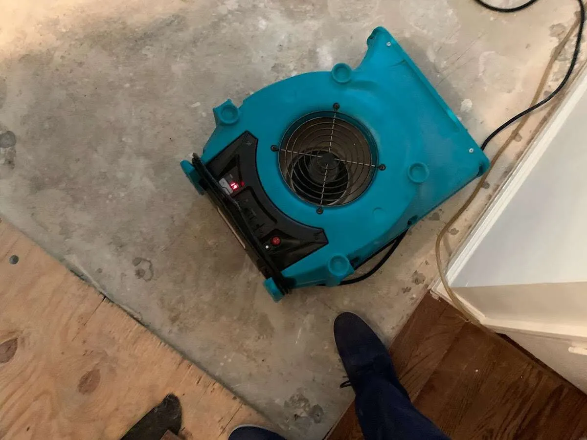 Air mover drying subfloor during Commercial Water Damage Restoration in Aldine